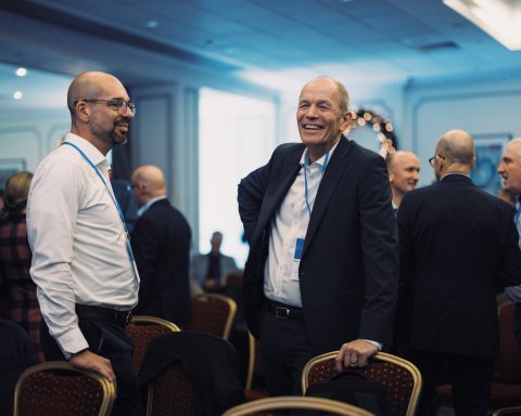Networking Business event attendees talking and smiling between sessions
