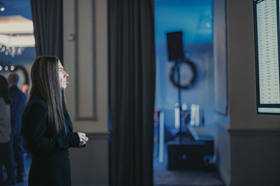 Conference guest Attendee standing near a doorway at an indoor business event