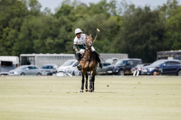 Player and pony Polo player on horseback waiting on the field with a raised mallet