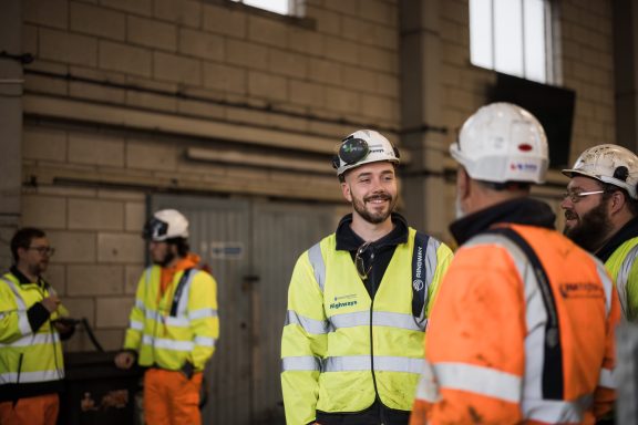 Site teamwork Construction workers in high-visibility clothing talking on site
