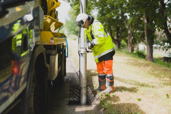 Infrastructure work Workers in high-visibility clothing installing a roadside post